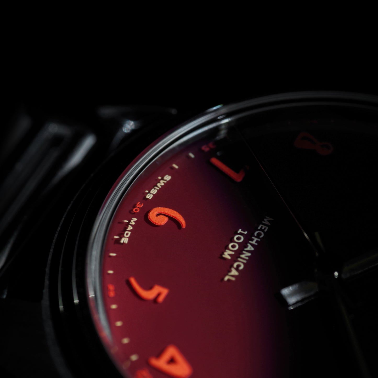 Close up of numerals on Swiss Made mechanical watch with 39mm deep red enamel lacquer dial for men and women designed by Camp Watches in Los Angeles.